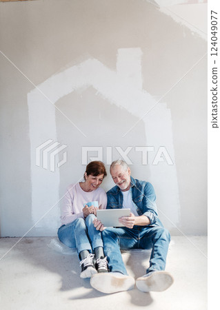 Senior couple renovating their home, browsing for inspirations on tablet. 124049077