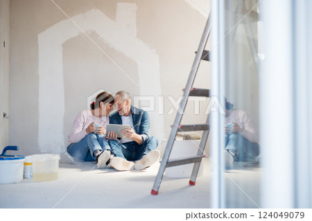 Senior couple renovating their home, browsing for inspirations on tablet. 124049079