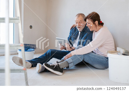 Senior couple renovating their home, browsing for inspirations on tablet. Senior couple renovating their home, browsing for inspirations on tablet. 124049137