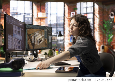 Worker in a creative office uses CAD software to design a house interior, provides a user interface for virtual home planning. Woman developer creating a precise architectural layout and adjustments. Worker in a creative office uses CAD software to design a house interior, provides a user interface for virtual home planning. Woman developer creating a precise architectural layout and adjustments. 124049362