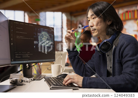 AI startup senior admin overseeing deep learning application, thinking how to improve software. Asian artificial intelligence tech venture computer scientist using PC to fix code bugs 124049383
