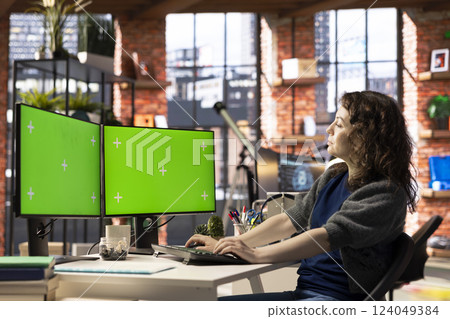 Developer in a smart office focuses on mockup screen dual monitors, working at the creative agency for projects. Technology driven workspace ideal for multitasking, efficiency. 124049384