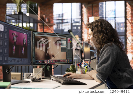 Woman using AI software to turn text prompt into photos and editing the skin, working with retouching interface program for media content. Uses text to image generative models on PC. 124049411