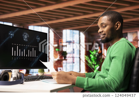 Upbeat teleworker using financial software user interface on PC screen in apartment showing company growth graphs. Man looking at sales statistics on computer display showing income figures Upbeat teleworker using financial software user interface on PC screen in apartment showing company growth graphs. Man looking at sales statistics on computer display showing income figures 124049437