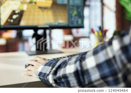 Interior designer uses 3D modeling program, selecting furniture from catalog, dragging objects across floor plan. Close up of man in home office using CAD software, arranging layout, positioning items 124049464