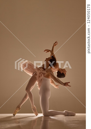 Graceful ballet duet moves in perfect harmony, man supporting woman as she leaning on him, capturing elegance, rhythm, and motion against soft warm light. Graceful ballet duet moves in perfect harmony, man supporting woman as she leaning on him, capturing elegance, rhythm, and motion against soft warm light. 124050178