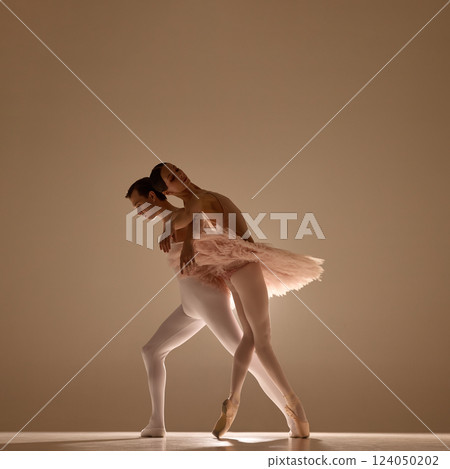 Ballet partners, man and woman, embrace in dramatic pose, close connection emphasized by warm light and soft focus. Ballet partners, man and woman, embrace in dramatic pose, close connection emphasized by warm light and soft focus. 124050202