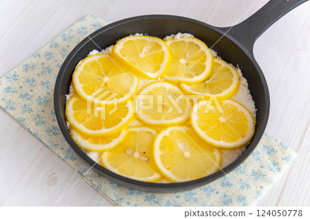 Spread sugar in a skillet and top with lemon slices. 124050778