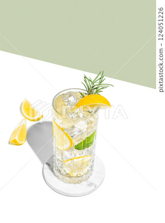 Refreshing mojito with lemon, rosemary and ice in a tall glass on a white green background 124051226