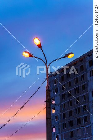 unfinished high-rise building against the backdrop of the sunset sky. building without finishing 124051427