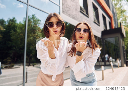 Giving air kiss. Two female friends have great weekend outdoors together Giving air kiss. Two female friends have great weekend outdoors together 124052423
