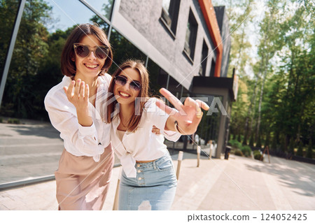 At sunny daytime. Two female friends have great weekend outdoors together At sunny daytime. Two female friends have great weekend outdoors together 124052425