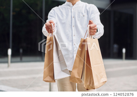 Shopping day. Stylish young man is outdoors with bags 124052876