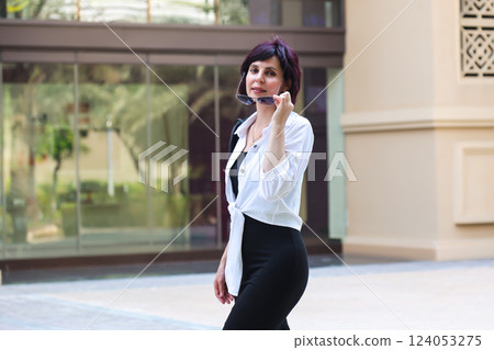 Stylish middle aged woman against modern buildings, calm city life 124053275