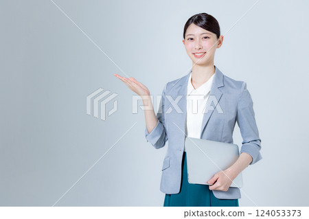 A female business person giving directions with a laptop A female business person giving directions with a laptop 124053373