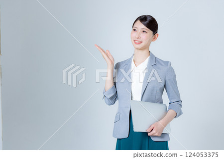 A female business person giving directions with a laptop 124053375
