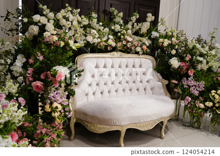 Luxury antique sofa in front of a wedding table with flowers 124054214