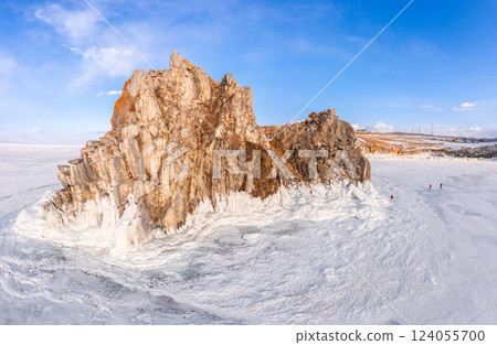 Aerial top view to famous Shamanka rock and small sea covered with snow. Winter landscape. Popular touristic destination, Clear ice. Cape Burkhan on Olkhon island, frozen Baikal lake, Siberia, Russia. Aerial top view to famous Shamanka rock and small sea covered with snow. Winter landscape. Popular touristic destination, Clear ice. Cape Burkhan on Olkhon island, frozen Baikal lake, Siberia, Russia. 124055700