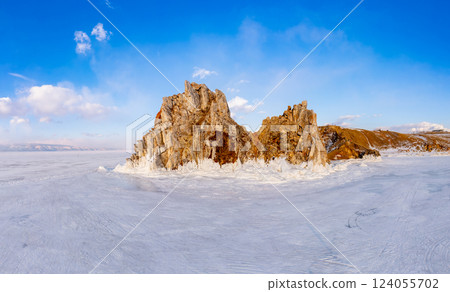 Aerial top view to famous Shamanka rock and small sea covered with snow. Winter landscape. Popular touristic destination, Clear ice. Cape Burkhan on Olkhon island, frozen Baikal lake, Siberia, Russia. Aerial top view to famous Shamanka rock and small sea covered with snow. Winter landscape. Popular touristic destination, Clear ice. Cape Burkhan on Olkhon island, frozen Baikal lake, Siberia, Russia. 124055702