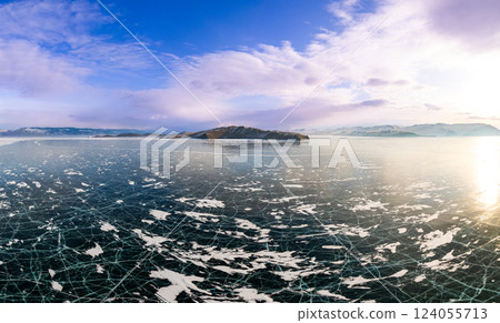 Aerial top view to Blue clear ice lake Baikal. Crack covered snow on frozen water surface. Cold winter landscape with mountains, sunny day, Natural background. Small Sea, Olkhon Gate, Russia, Siberia. 124055713