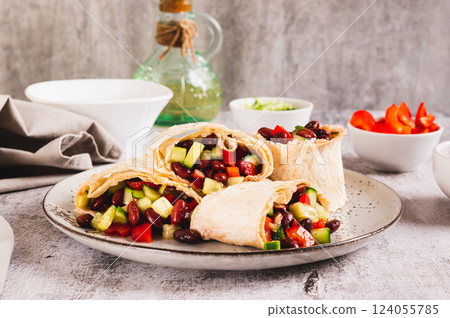 Salad of beans, cucumber and pepper in lavash rolls on a plate on the table Salad of beans, cucumber and pepper in lavash rolls on a plate on the table 124055785