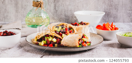 Salad of beans, cucumber and pepper in lavash rolls on a plate on the table web banner Salad of beans, cucumber and pepper in lavash rolls on a plate on the table web banner 124055793
