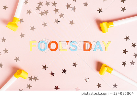 April Fools' Day written in colored letters, whistles, stars and tulips on pink top view April Fools' Day written in colored letters, whistles, stars and tulips on pink top view 124055804