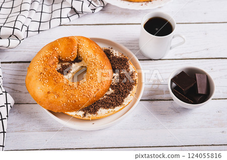 Sweet sandwich with butter, chocolate and sesame seeds on a plate on a table 124055816