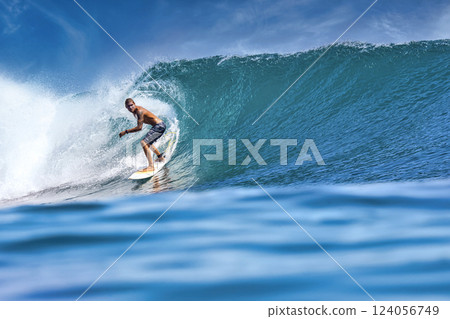 Male surfer on a blue wave 124056749
