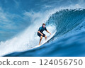 Male surfer on a blue wave 124056750