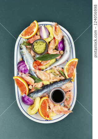 Marinating fresh raw seafood on table, fish delicacy Marinating fresh raw seafood on table, fish delicacy 124056998