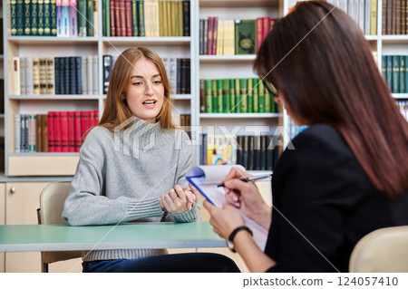 Young teenage girl student meeting with female college psychologist counselor 124057410