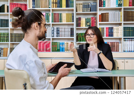 Middle aged female mental health specialist working with young male patient 124057417