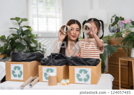 Recycling and Creative Play. Engaging hands-on activity where a mother and daughter explore recycled materials, fostering creativity and environmental care. 124057485