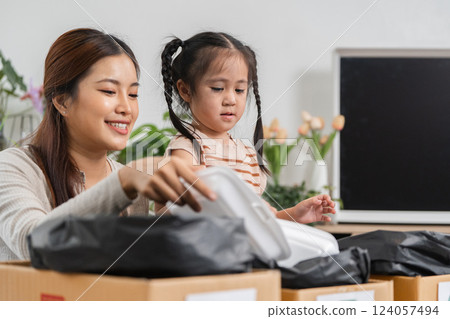Sustainability and Family Bonding. A mother and her daughter enthusiastically sorting recyclable materials together. 124057494
