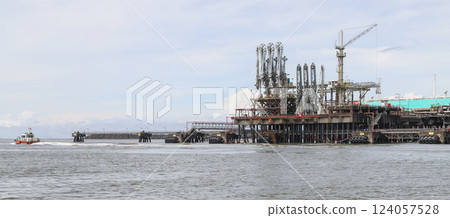 Offshore oil jetty operating in open water, featuring cranes and pipelines Offshore oil jetty operating in open water, featuring cranes and pipelines 124057528