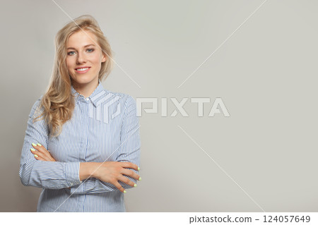 Happy young adult smiling business woman wearing shirt standing with crossed hands Happy young adult smiling business woman wearing shirt standing with crossed hands 124057649