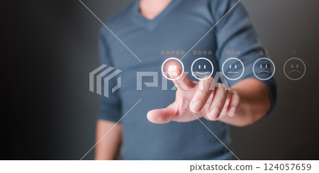 A man touches the icon on the happy smile face and gives five stars to indicate satisfaction with the service. Feedback, survey, and review concept. Rating: Very impressed. 124057659