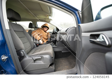 Comfort and contemplation in a cozy vehicle on a chilly day, featuring a lone traveler in a warm jacket lost in thought 124058145