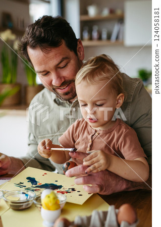 Father and little son decorating easter eggs at home. 124058181