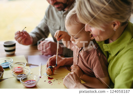 Family decorating easter eggs at home. 124058187