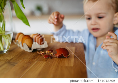 Little boy and easter eggs dyed with onion skins. 124058206