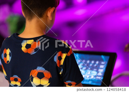 Primary school boy using big touch screen display and delighted looking around. Children and modern technology concepts. 124058418