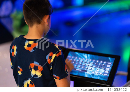 Primary school boy using big touch screen display and delighted looking around. Children and modern technology concepts. Primary school boy using big touch screen display and delighted looking around. Children and modern technology concepts. 124058422