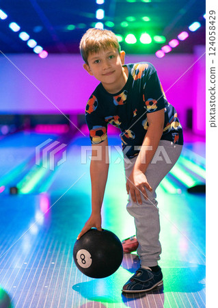 happy young boy child have fun cheering while playing bowling game bowling alley happy young boy child have fun cheering while playing bowling game bowling alley 124058429