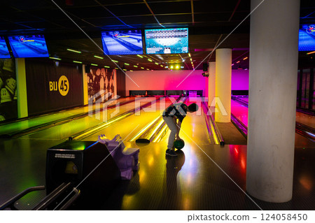 Young boy child having fun and playing bowling Young boy child having fun and playing bowling 124058450