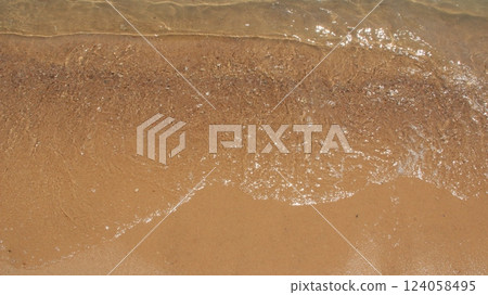 Sea waves on the sandy shore. Water on the beach. Sea holiday. Holidays at sea 124058495