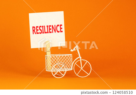 Resilience symbol. Concept word Resilience on beautiful white paper on clothespin. Beautiful orange background. Beautiful miniature white bicycle. Business resilience concept. Copy space. 124058510