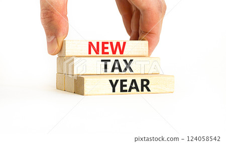 New tax year symbol. Concept words New tax year on beautiful wooden blocks. Beautiful white table white background. Businessman hand. Business new tax year concept. Copy space. 124058542