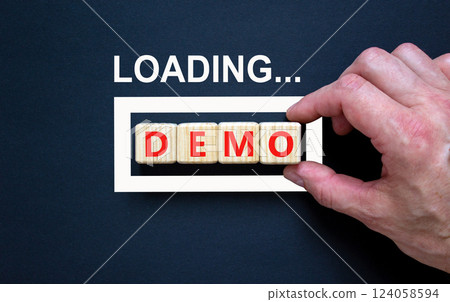 Demo symbol. Concept word Loading Demo on beautiful wooden blocks. Businessman hand. Beautiful black table black background. Business and demo concept. Copy space. 124058594